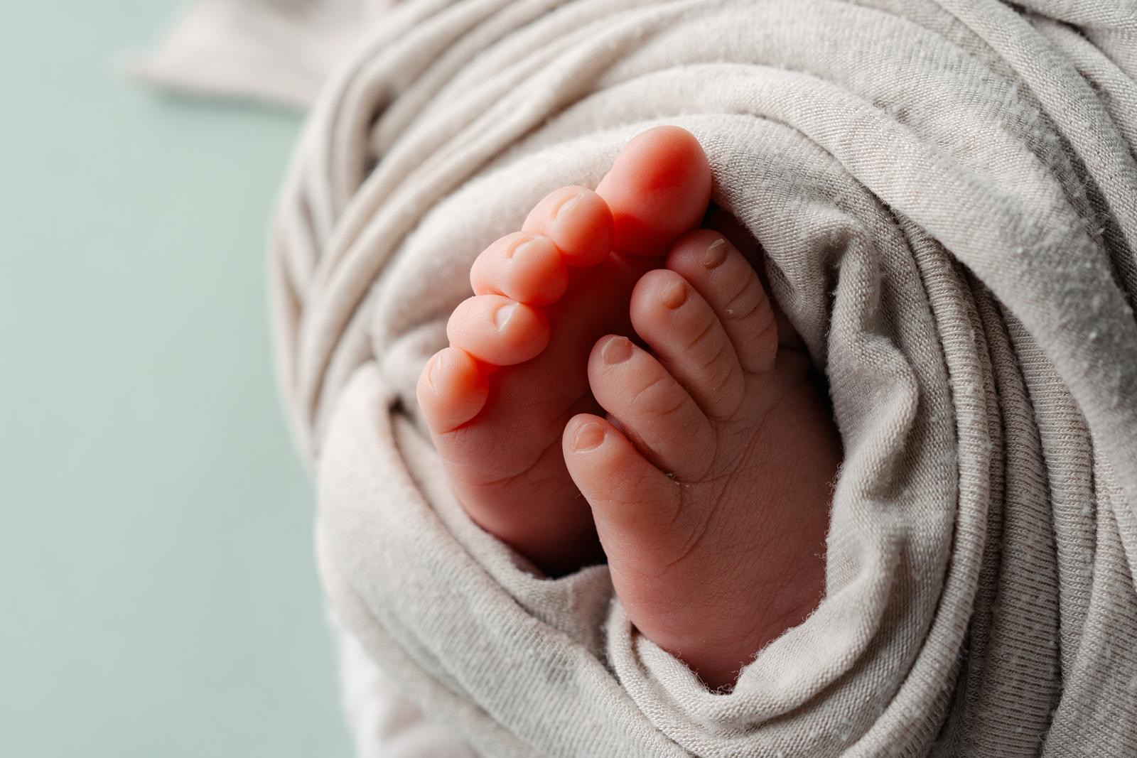 Newborn baby feet wrapped in a soft blanket